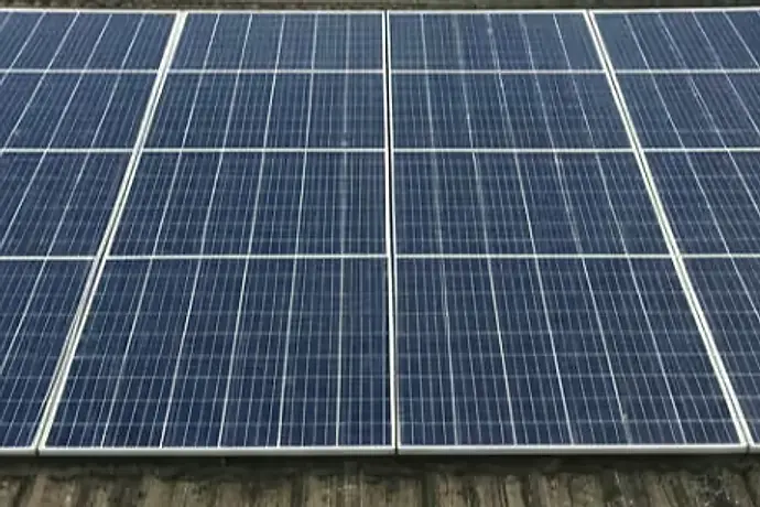 Zonnepanelen op een pannendak na reiniging, weer schoon en donkerblauw