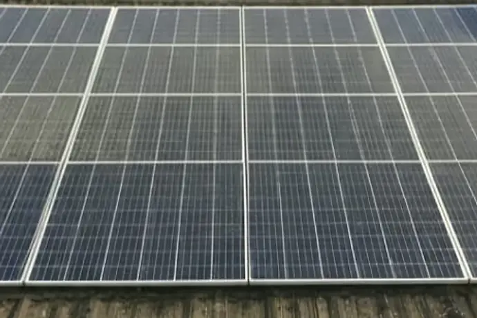 Dezelfde zonnepanelen vóór reiniging, met een grijze vuilfilm